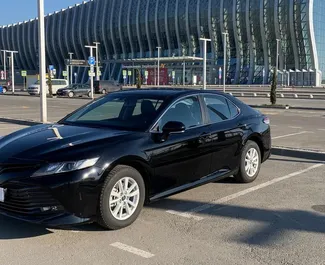 Vista frontale di un noleggio Toyota Camry all'aeroporto di Simferopol, Crimea ✓ Auto #1825. ✓ Cambio Automatico TM ✓ 0 recensioni.