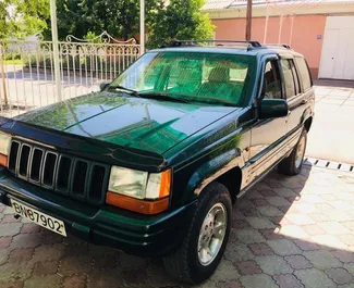 Vista frontale di un noleggio Jeep Grand Cherokee a Osh, Kirghizistan ✓ Auto #7074. ✓ Cambio Automatico TM ✓ 0 recensioni.