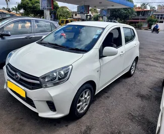 Vista frontale di un noleggio Perodua Axia all'aeroporto di Mauritius, Mauritius ✓ Auto #7330. ✓ Cambio Automatico TM ✓ 0 recensioni.