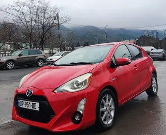 Vista frontale di un noleggio Toyota Prius C a Tbilisi, Georgia ✓ Auto #9302. ✓ Cambio Automatico TM ✓ 0 recensioni.