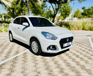 Vista frontale di un noleggio Suzuki Dzire all'aeroporto di Dubai Al Maktoum, Emirati Arabi Uniti ✓ Auto #9131. ✓ Cambio Automatico TM ✓ 0 recensioni.