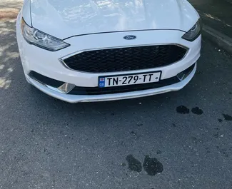 Vista frontale di un noleggio Ford Fusion Sedan a Tbilisi, Georgia ✓ Auto #9726. ✓ Cambio Automatico TM ✓ 0 recensioni.