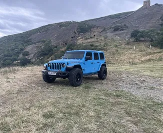 Vista frontale di un noleggio Jeep Wrangler Rubicon a Tbilisi, Georgia ✓ Auto #10528. ✓ Cambio Automatico TM ✓ 0 recensioni.