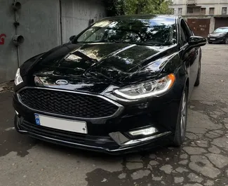 Vista frontale di un noleggio Ford Fusion Sedan a Tbilisi, Georgia ✓ Auto #10821. ✓ Cambio Automatico TM ✓ 0 recensioni.