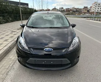 Vista frontale di un noleggio Ford Fiesta all'aeroporto di Tirana, Albania ✓ Auto #11057. ✓ Cambio Manuale TM ✓ 0 recensioni.