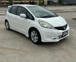 Vista frontale di un noleggio Honda Jazz all'aeroporto Suvarnabhumi di Bangkok, Thailandia ✓ Auto #11206. ✓ Cambio Automatico TM ✓ 0 recensioni.