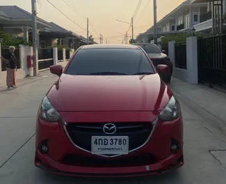 Vista frontale di un noleggio Mazda 2 all'aeroporto Suvarnabhumi di Bangkok, Thailandia ✓ Auto #11199. ✓ Cambio Automatico TM ✓ 0 recensioni.