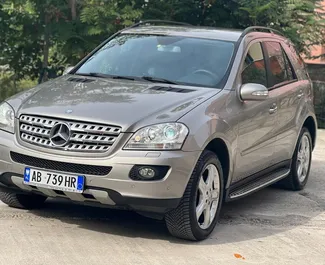 Vista frontale di un noleggio Mercedes-Benz ML320 all'aeroporto di Tirana, Albania ✓ Auto #11158. ✓ Cambio Automatico TM ✓ 0 recensioni.