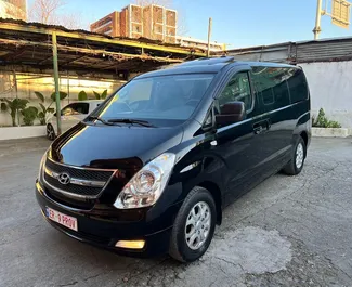 Vista frontale di un noleggio Hyundai Grand Starex all'aeroporto di Tirana, Albania ✓ Auto #11159. ✓ Cambio Automatico TM ✓ 0 recensioni.