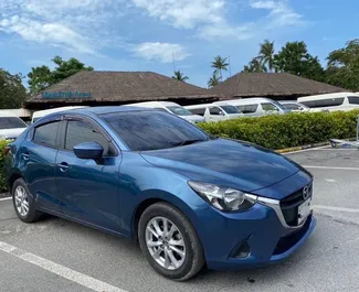 Vista frontale di un noleggio Mazda 2 all'aeroporto di Samui, Thailandia ✓ Auto #11708. ✓ Cambio Automatico TM ✓ 0 recensioni.
