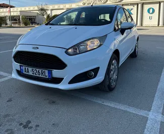 Vista frontale di un noleggio Ford Fiesta all'aeroporto di Tirana, Albania ✓ Auto #11488. ✓ Cambio Manuale TM ✓ 0 recensioni.