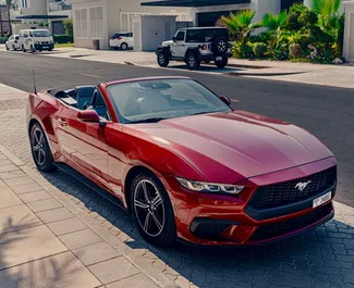 Vista frontale di un noleggio Ford Mustang Cabrio all'aeroporto di Dubai Al Maktoum, Emirati Arabi Uniti ✓ Auto #11030. ✓ Cambio Automatico TM ✓ 0 recensioni.