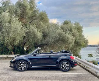 Vista frontale di un noleggio Volkswagen Beetle Cabrio a Budva, Montenegro ✓ Auto #13165. ✓ Cambio Automatico TM ✓ 0 recensioni.
