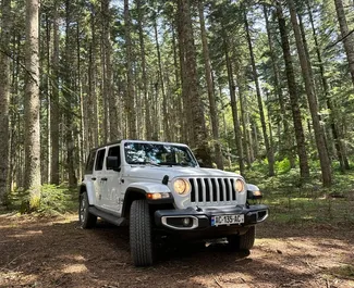 Vista frontale di un noleggio Jeep Wrangler Sahara a Tbilisi, Georgia ✓ Auto #13658. ✓ Cambio Automatico TM ✓ 0 recensioni.