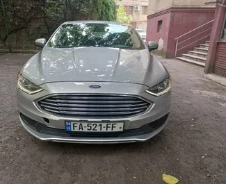 Vista frontale di un noleggio Ford Fusion Sedan a Tbilisi, Georgia ✓ Auto #14832. ✓ Cambio Automatico TM ✓ 0 recensioni.