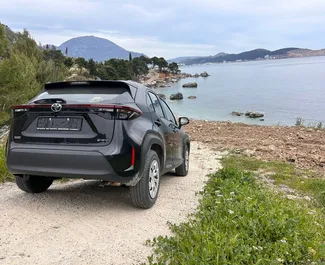 Vista frontale di un noleggio Toyota Yaris Cross all'aeroporto di Podgorica, Montenegro ✓ Auto #15687. ✓ Cambio Automatico TM ✓ 0 recensioni.
