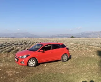 Vista frontale di un noleggio Hyundai i20 all'aeroporto di Podgorica, Montenegro ✓ Auto #15721. ✓ Cambio Automatico TM ✓ 0 recensioni.