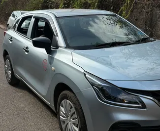 Vista frontale di un noleggio Suzuki Baleno all'aeroporto di Goa, Goa ✓ Auto #16196. ✓ Cambio Manuale TM ✓ 0 recensioni.
